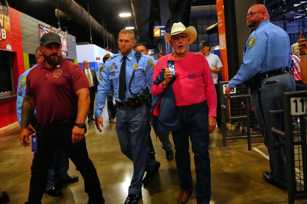 Police remove a protester as President Donald Trump speaks at a campaign rally at Heartland...