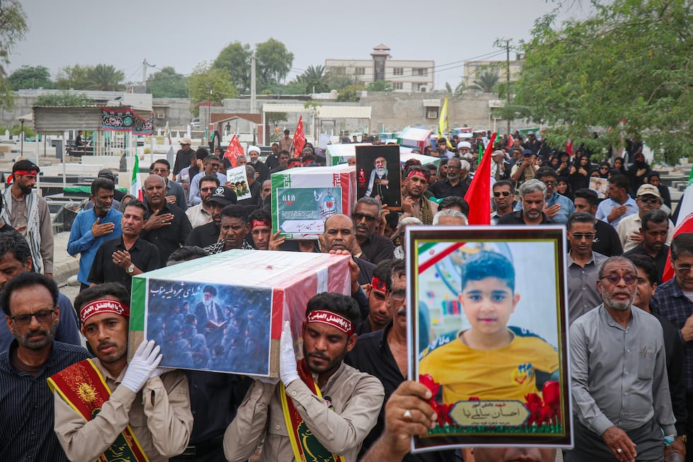 Mourners carry the coffins containing additional remains of victims identified through DNA...